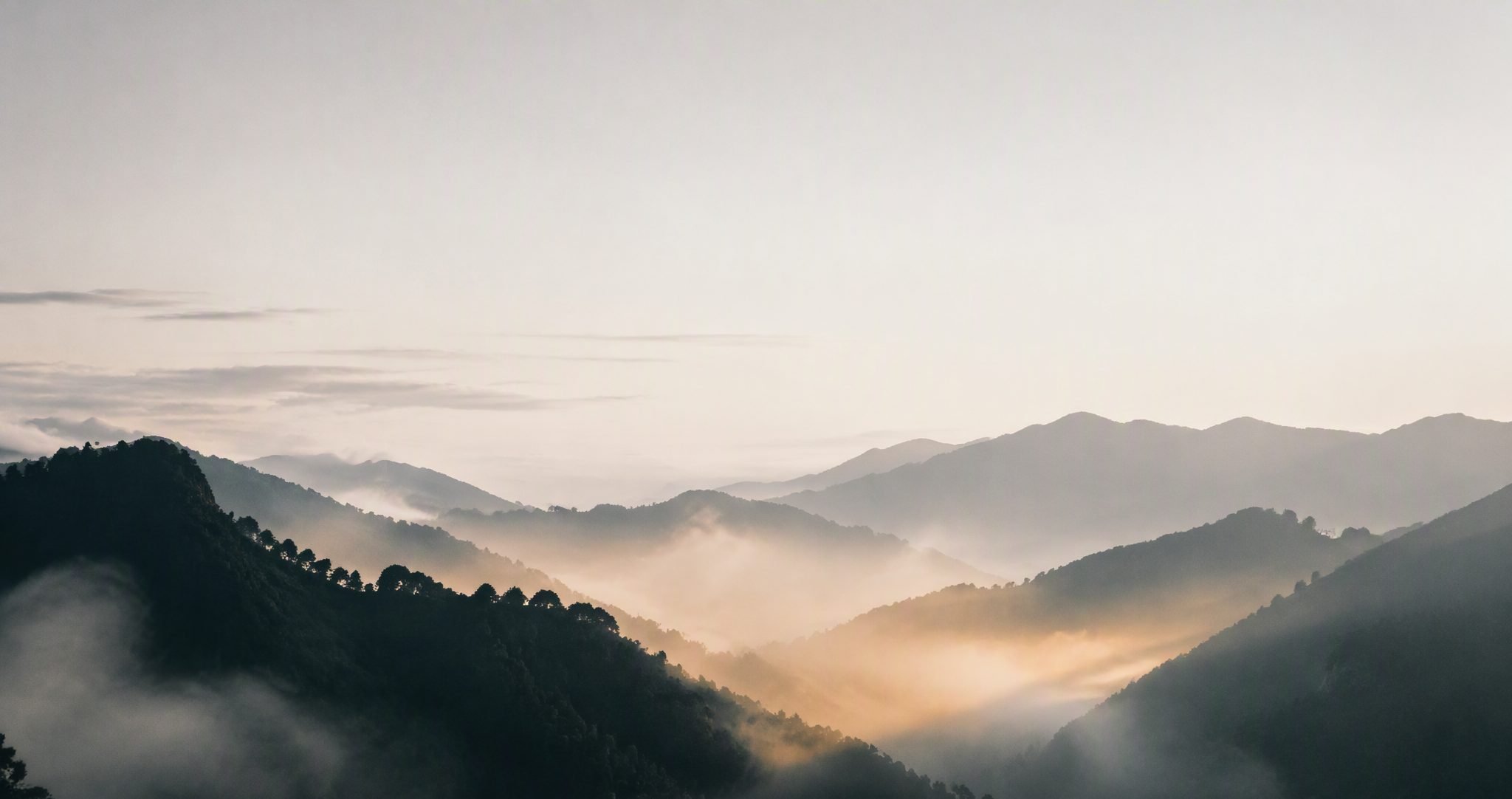 晨霧繚繞的山巒,晨光自山谷間升起